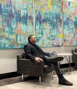 Alexander Franco sits in front of his Blue Lagoon Triptych in Las Vegas.